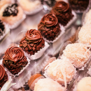 Assorted chocolate truffles and coconut-coated sweets arranged in paper cups on a tray