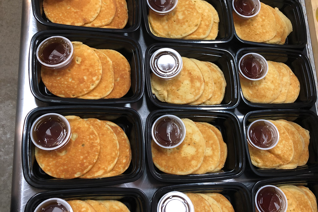 Black trays of golden cookies with small cups of chocolate dipping sauce