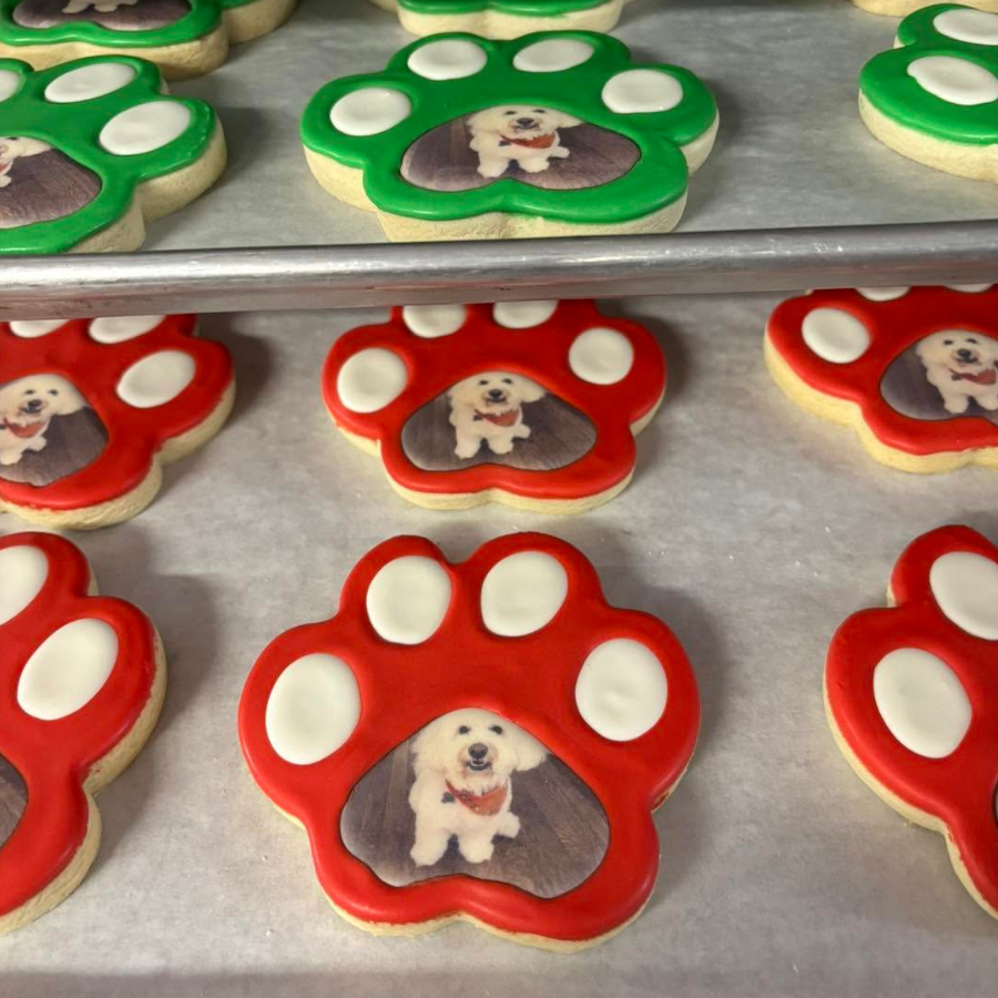 Tray of red and green paw-shaped cookies with a small dog image in each center