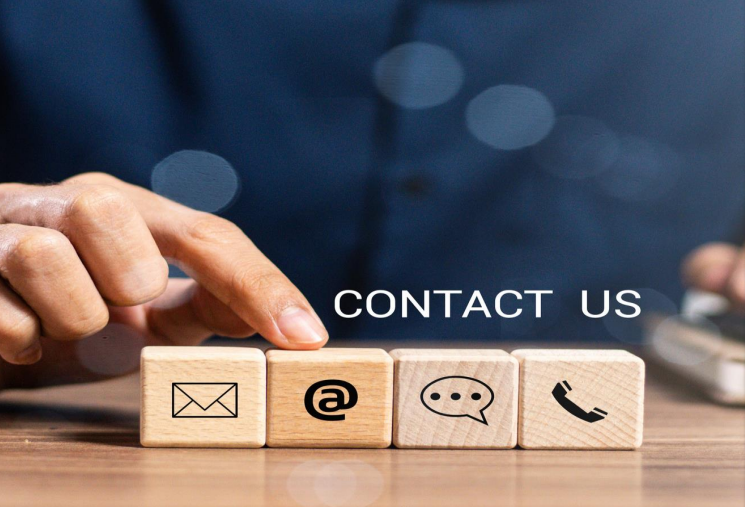 Hand placing wooden blocks with contact icons and “CONTACT US” text on a blue background