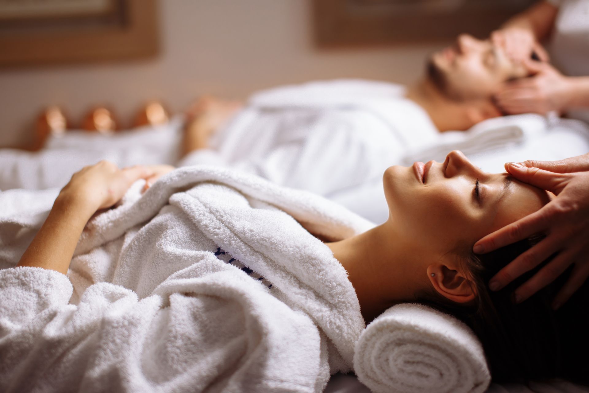 Ein Mann und eine Frau bekommen in einem Spa eine Kopfmassage.
