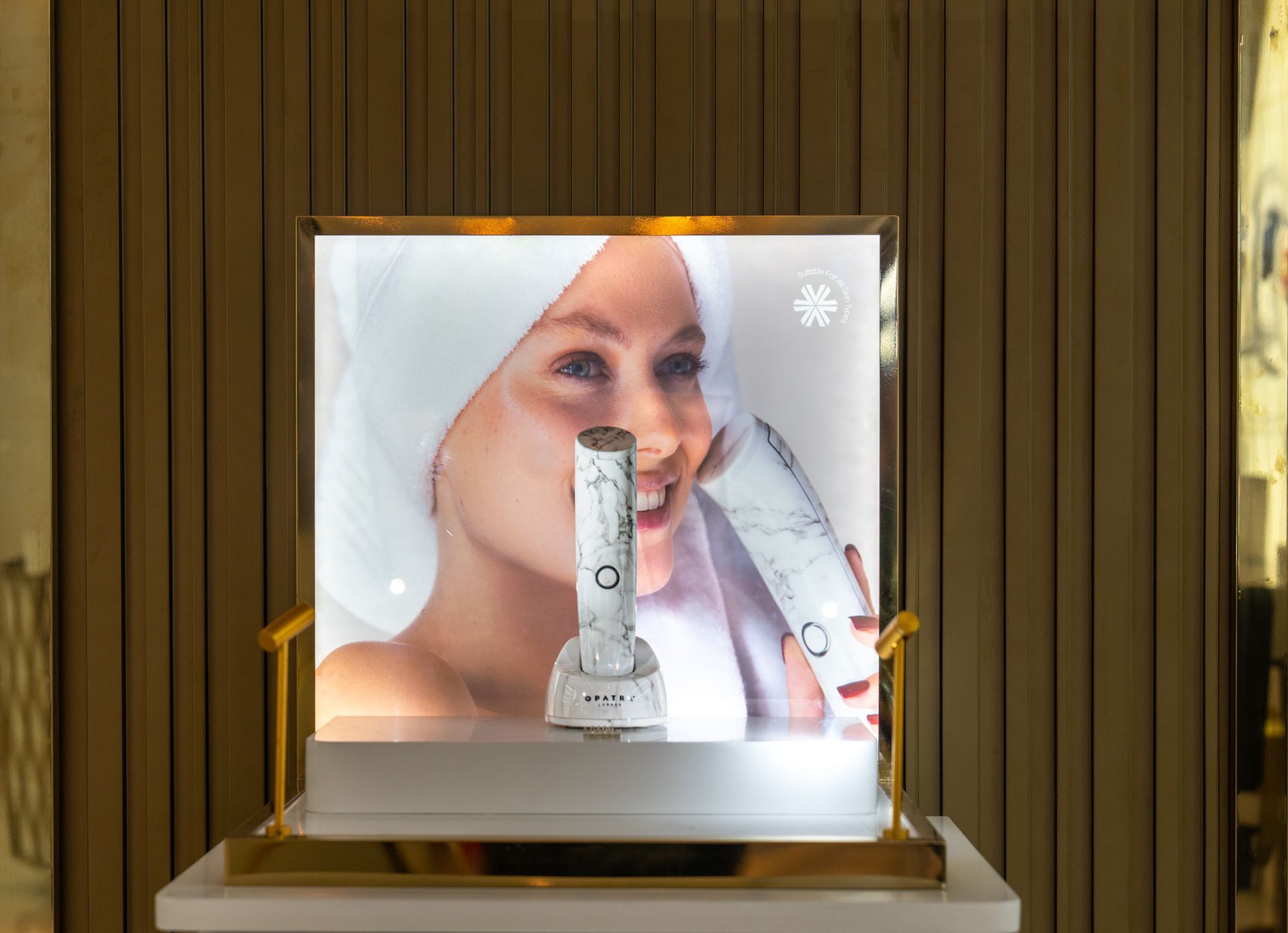 Eine Frau hat ein Handtuch um den Kopf gewickelt und hält eine Flasche Lotion in der Hand.