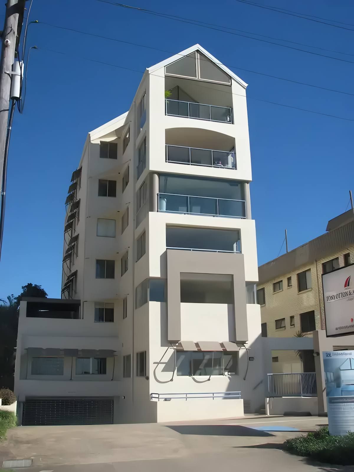A Tall Yellow Building With a Sign That Says 'abercrombie & Fitch' on It — O'Brien Painting Contractors in Alexandra Headland, QLD