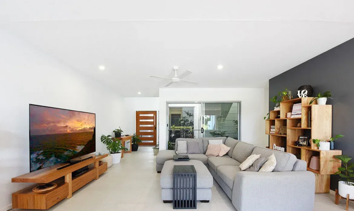A Living Room With a Large Sectional Couch and a Flat Screen Tv — O'Brien Painting Contractors in Alexandra Headland, QLD 