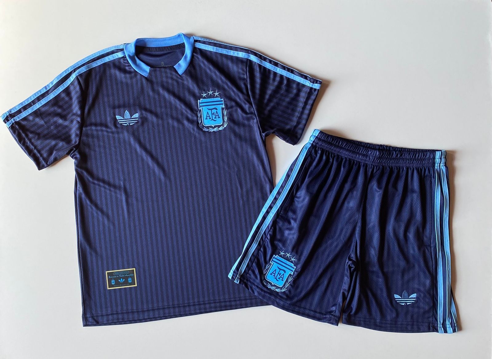 Camiseta de fútbol argentina azul oscuro y pantalón corto a juego con ribetes azul claro y logotipos de Adidas.