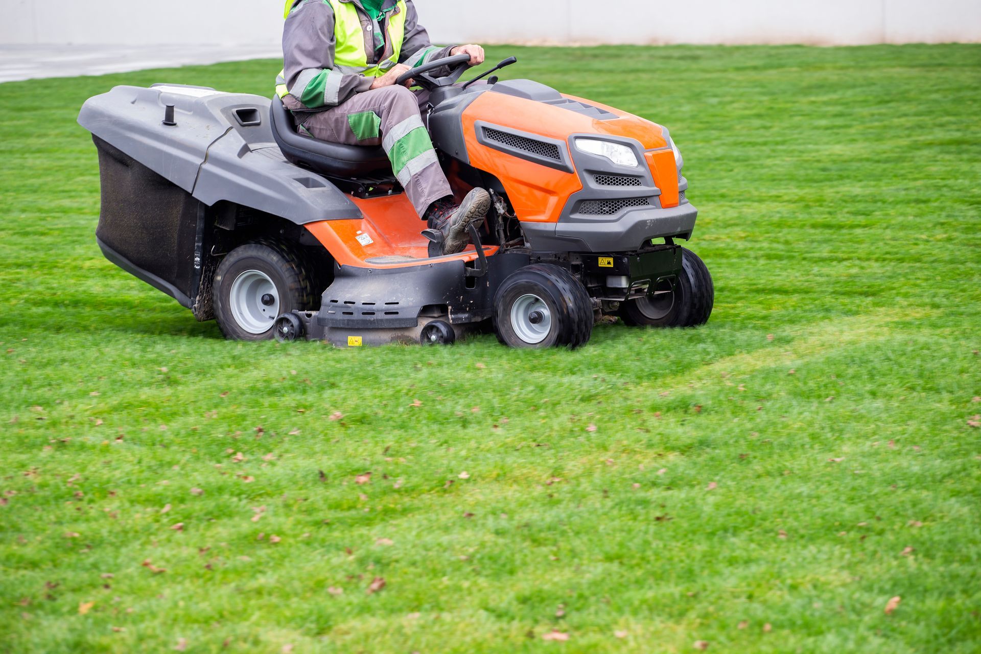 a man is riding a lawn mower on a lush green lawn .