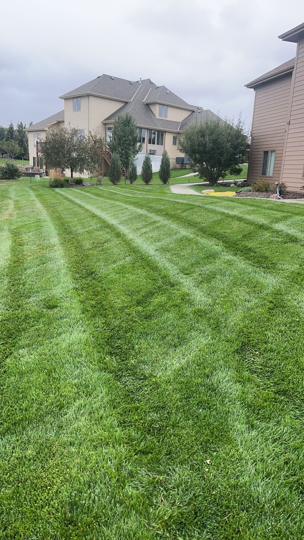 A Lush Green Lawn is Being Mowed in Front of a House