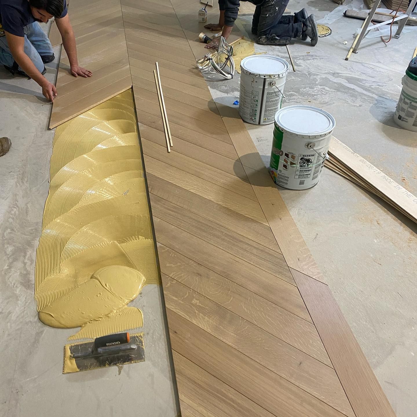 A group of people are working on a wooden floor.