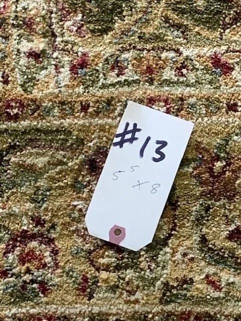 A tag with the number 13 on it is sitting on top of a rug.