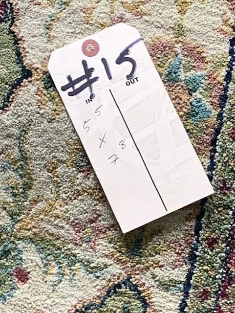 A tag with the number 15 on it is on a rug