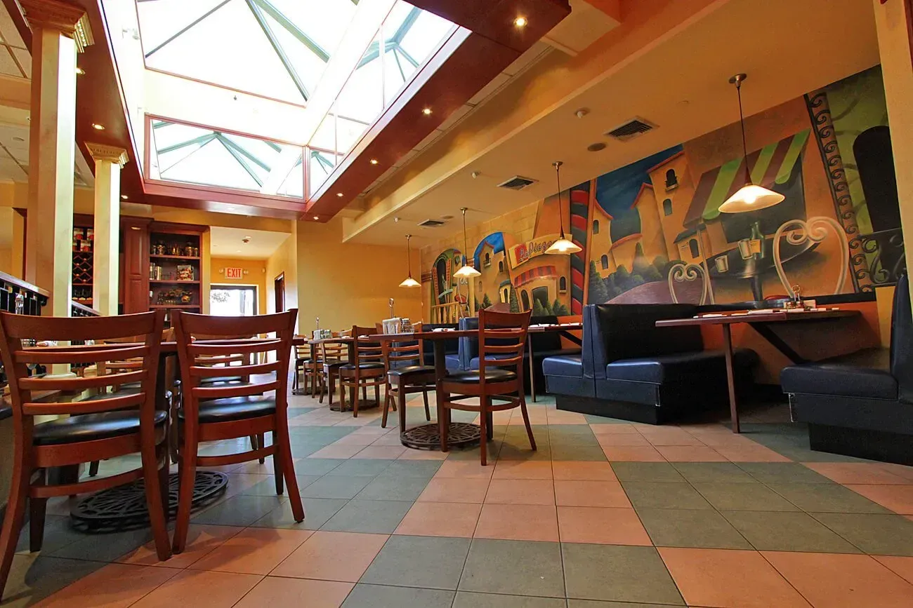 A restaurant with tables and chairs and a skylight
