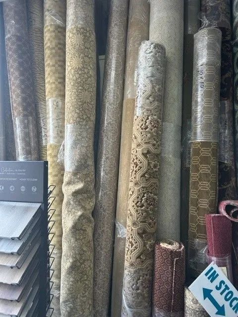 A bunch of carpets are stacked on top of each other in a store.