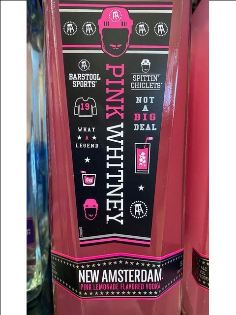 A bottle of pink whitney is sitting on a table.