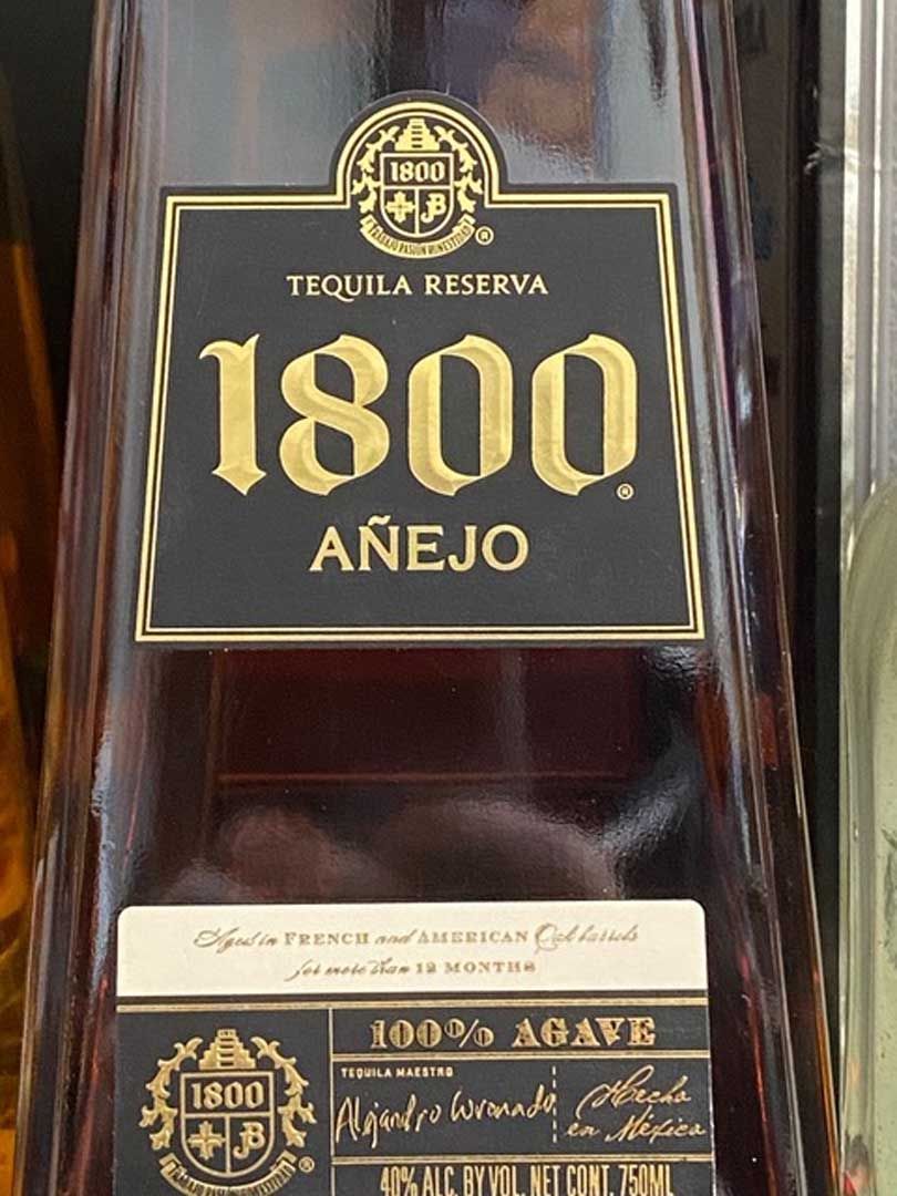 A close up of a bottle of 1800 añejo tequila