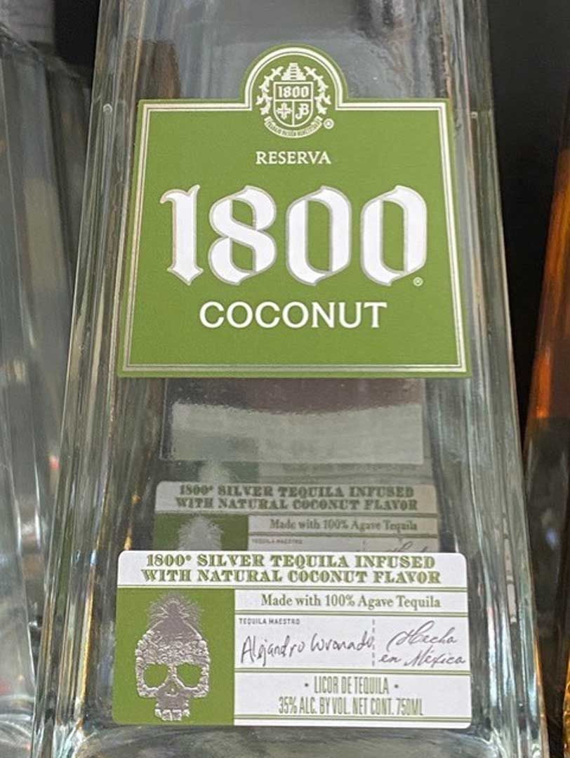 A bottle of 1800 coconut tequila is sitting on a table.