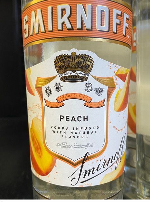A bottle of smirnoff peach vodka infused with natural flavors