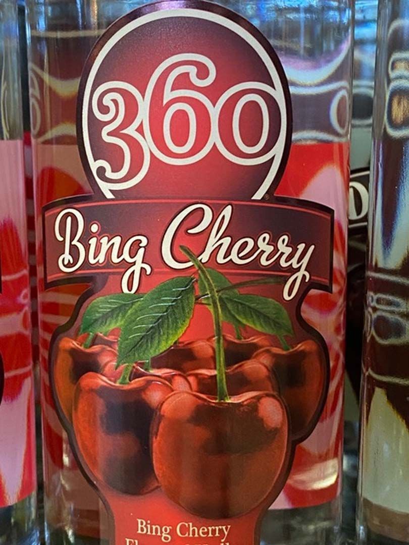 A bottle of 360 bing cherry liquor with a cherry on the label