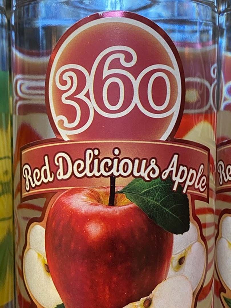 A bottle of red delicious apple juice with a picture of an apple on the label.
