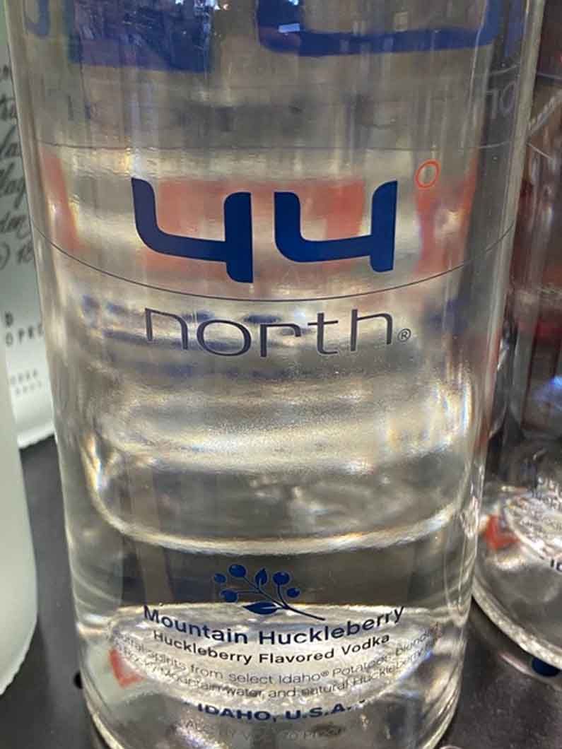 A glass of mountain huckleberry vodka is sitting on a table.