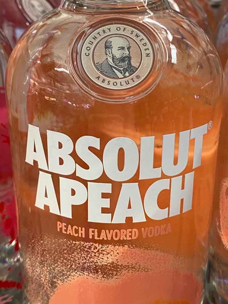 A close up of a bottle of absolut apeach peach flavored vodka