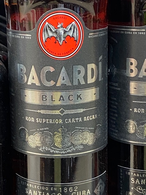 A bottle of bacardi black rum with a bat on the label