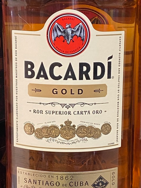 A bottle of bacardi gold has a bat on the label