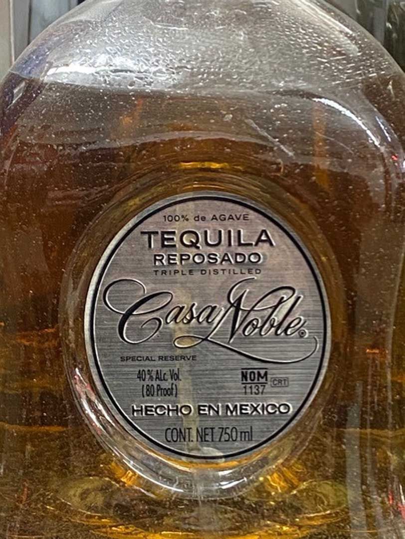 A bottle of tequila is sitting on a shelf in a store.