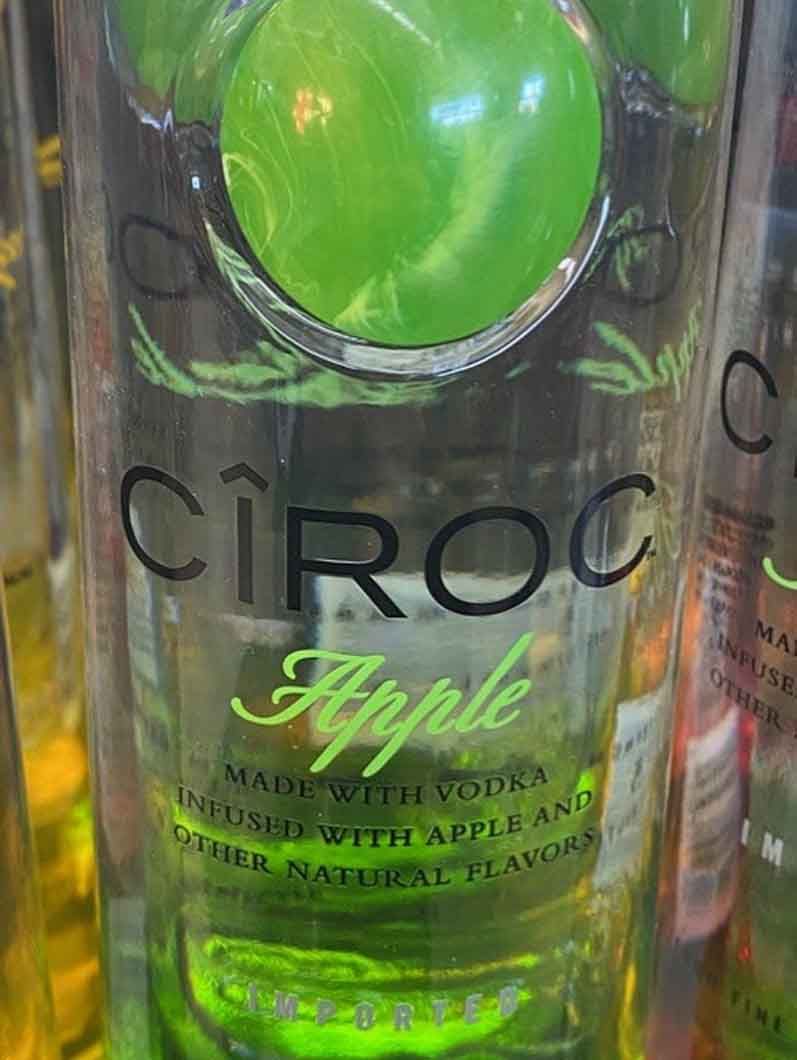 A close up of a bottle of ciroc apple vodka.