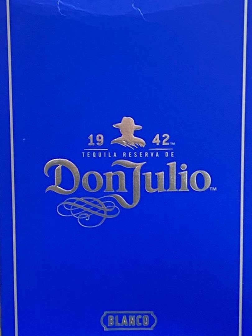 A blue box of don julio tequila is sitting on a table.