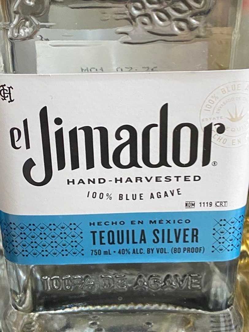 A close up of a bottle of el jimador tequila silver