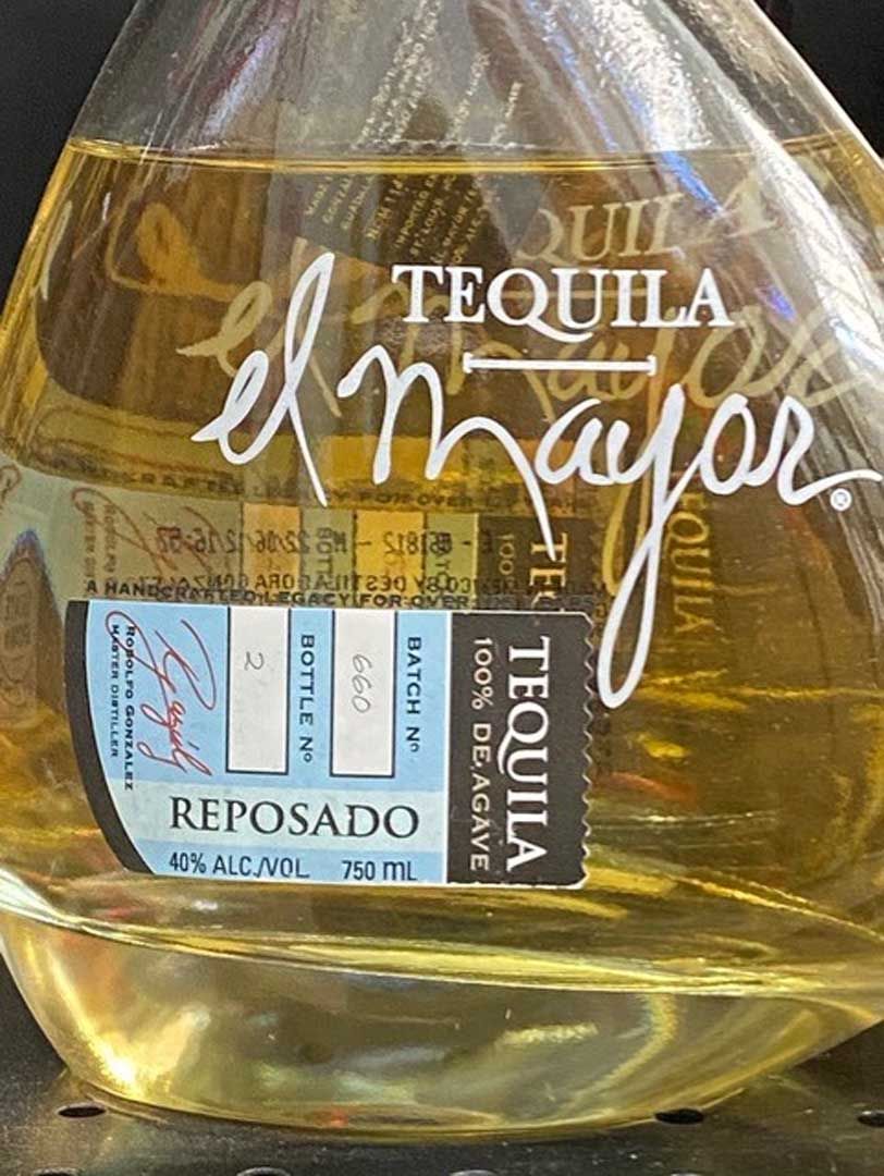 A bottle of tequila reposado is sitting on a table