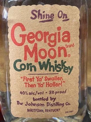 A bottle of georgia moon corn whiskey is sitting on a table.