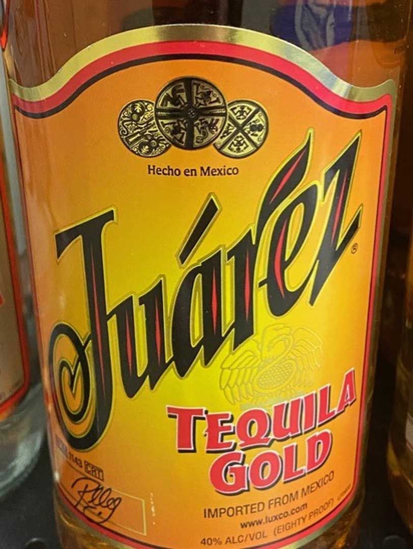 A close up of a bottle of juarez tequila gold