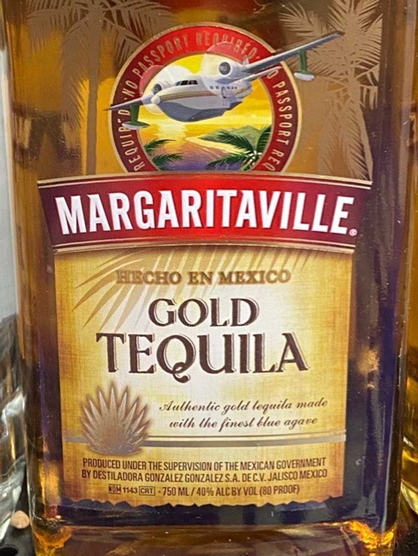 A bottle of margaritaville gold tequila is sitting on a table.