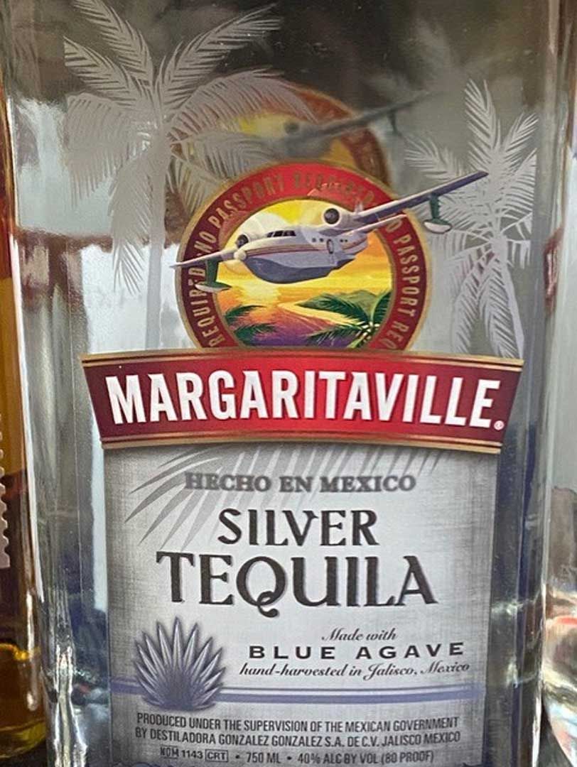 A bottle of margaritaville silver tequila is sitting on a table.