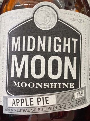 A bottle of midnight moon moonshine apple pie grain neutral spirits with natural flavors.