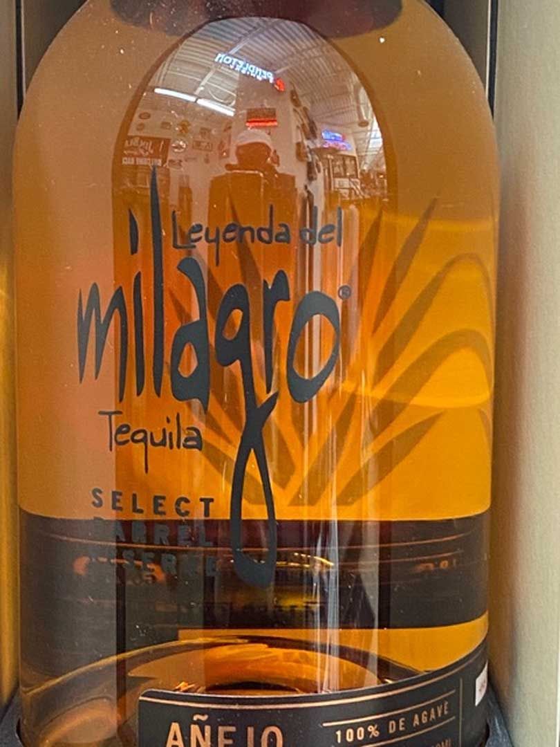 A bottle of milagros tequila is sitting on a table