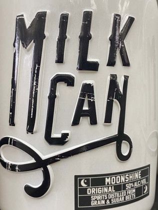 A close up of a milk can with scissors on it.