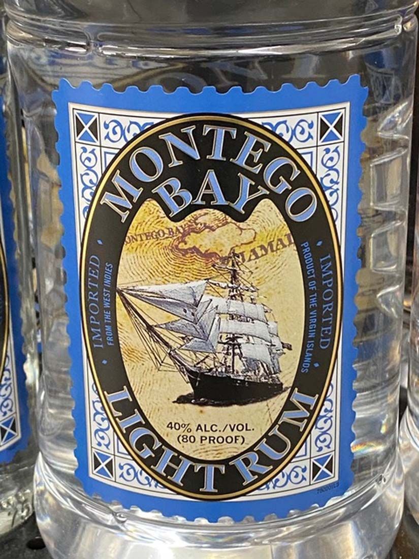 A bottle of montego bay light rum with a sailboat on the label