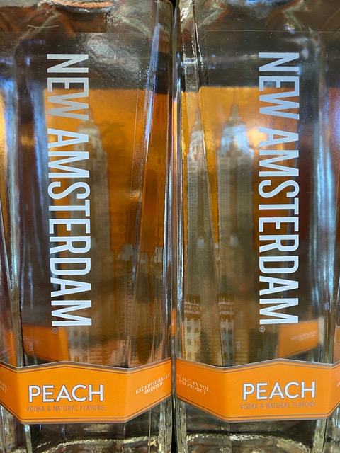 Two bottles of new amsterdam peach vodka on a shelf