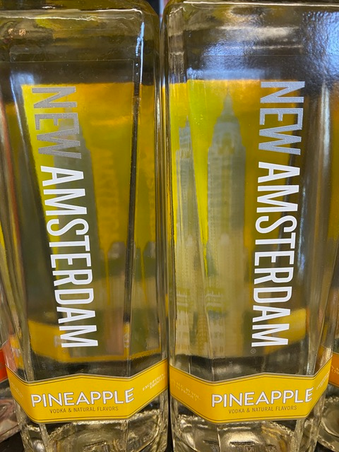 Two bottles of new amsterdam pineapple vodka on a table