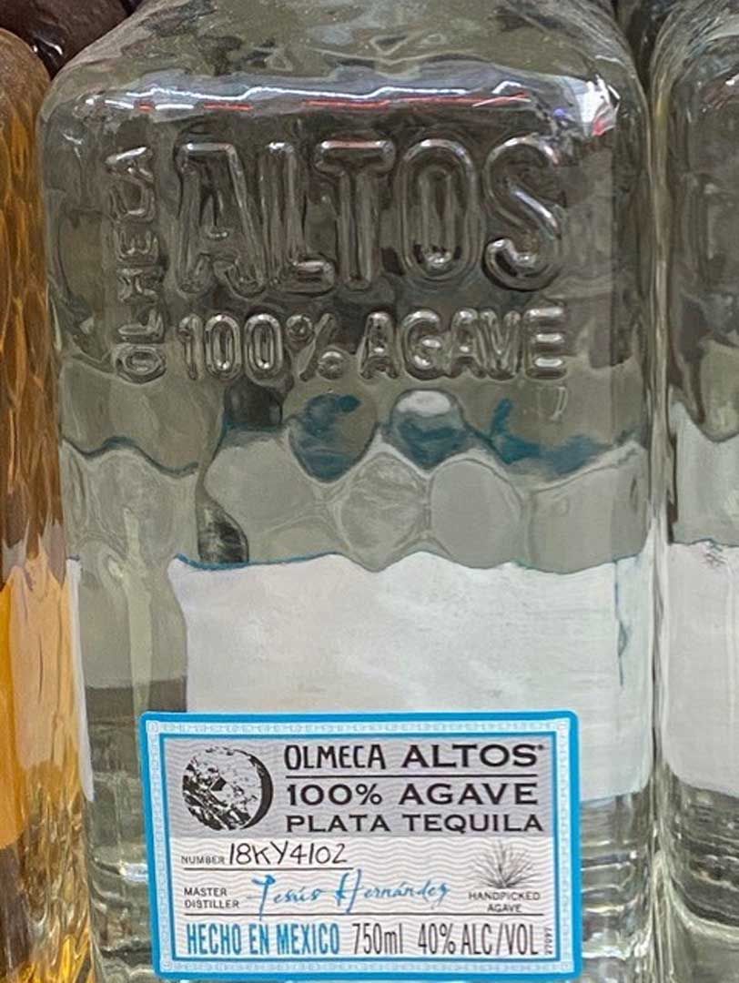 A close up of a bottle of tequila with a blue label.