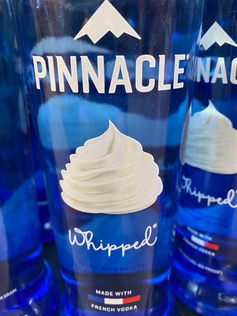 A bottle of pinnacle whipped vodka with whipped cream on top
