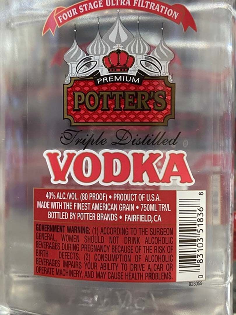A bottle of potter 's triple distilled vodka is sitting on a table.