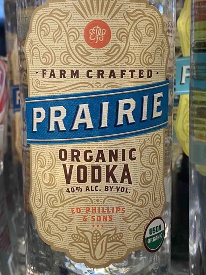 A bottle of prairie organic vodka is sitting on a shelf.