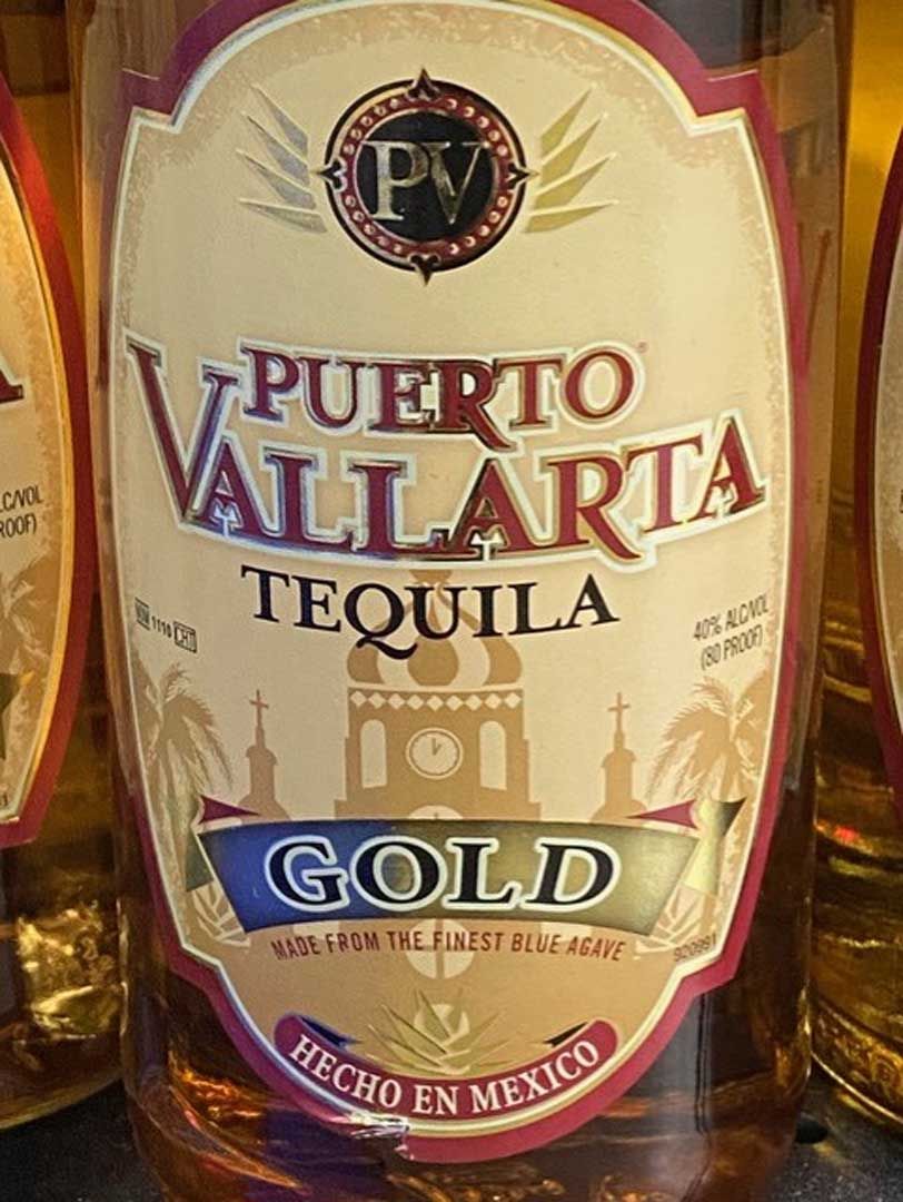 A bottle of puerto vallarta tequila gold is sitting on a table.