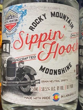 A close up of a bottle of rocky mountain sippin ' hood moonshine.