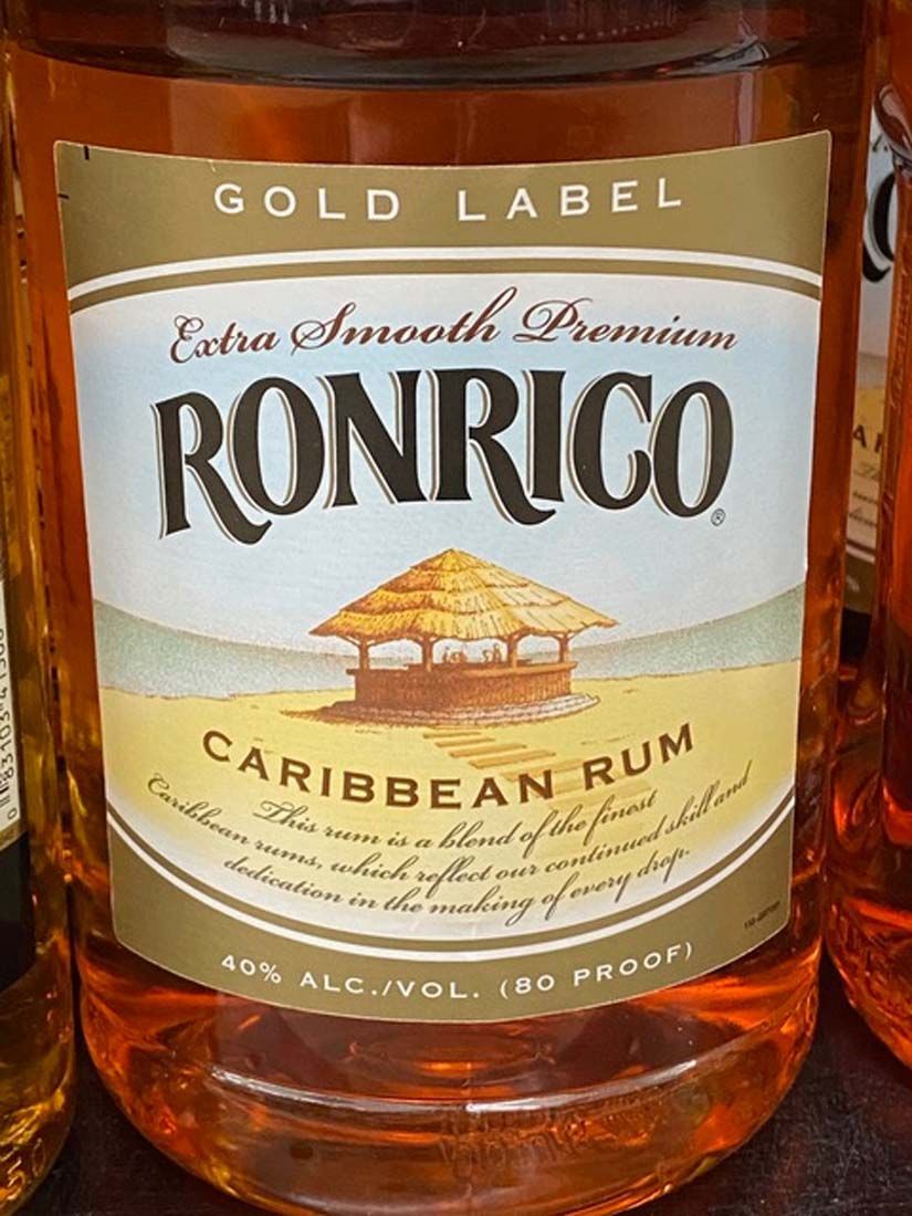 A bottle of ronrico caribbean rum with a gold label