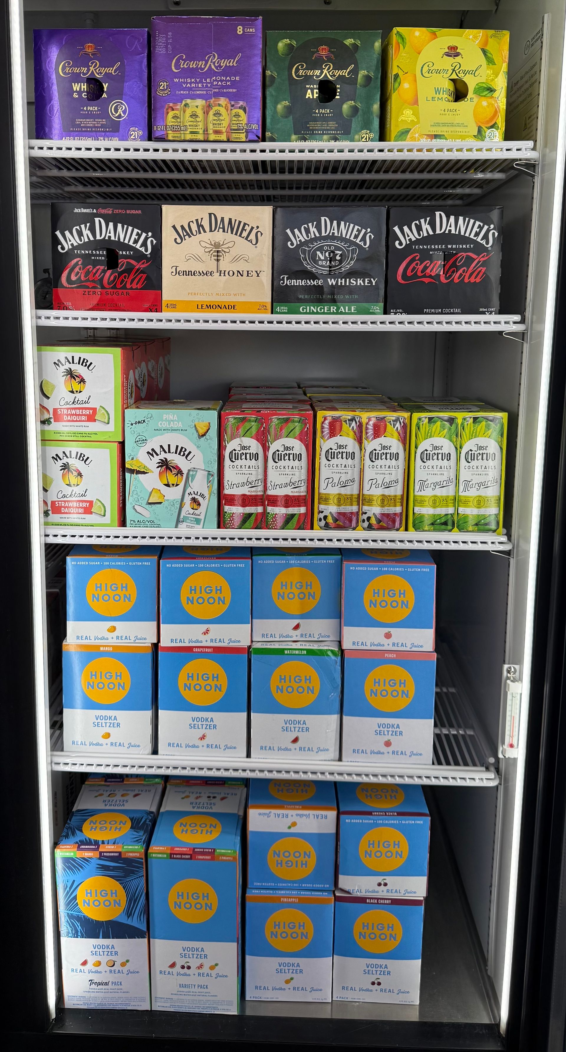 Refrigerated display case with various canned drinks. Jack Daniel's and colorful beverages are visible.