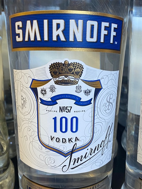 A bottle of smirnoff 100 vodka is sitting on a table